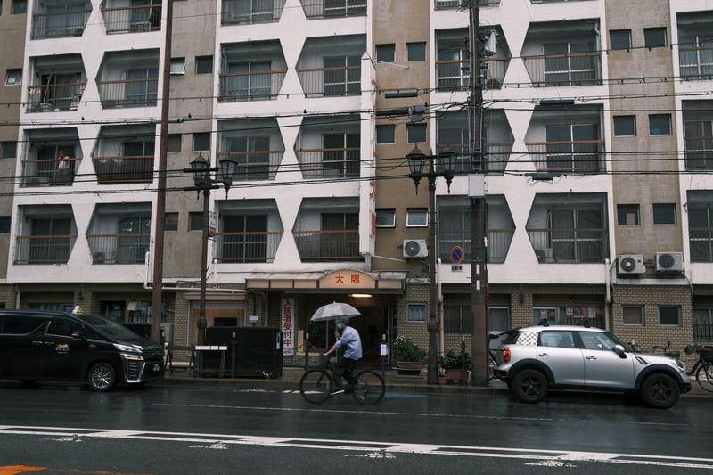 雨の朝 団地の前を行く自転車